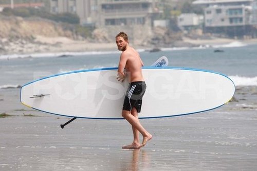 Robert Pattinson carried his paddleboard on the beach.
Robert Pattinson carried his paddleboard on the beach.