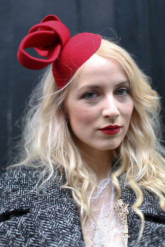 A quirky fascinator lent infinite personality and echoed the red hue on her lips.
A quirky fascinator lent infinite personality and echoed the red hue on her lips.