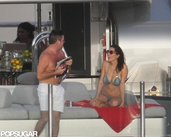Shirtless Simon Cowell read magazines while Mezhgan Hussainy lounged in a bikini. Shirtless Simon Cowell read magazines while Mezhgan Hussainy lounged in a bikini.