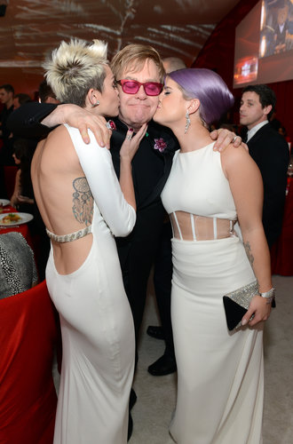 Mily Cyrus and Kelly Osbourne kissed Elton John on the cheek at his Oscar viewing party.
Mily Cyrus and Kelly Osbourne kissed Elton John on the cheek at his Oscar viewing party.