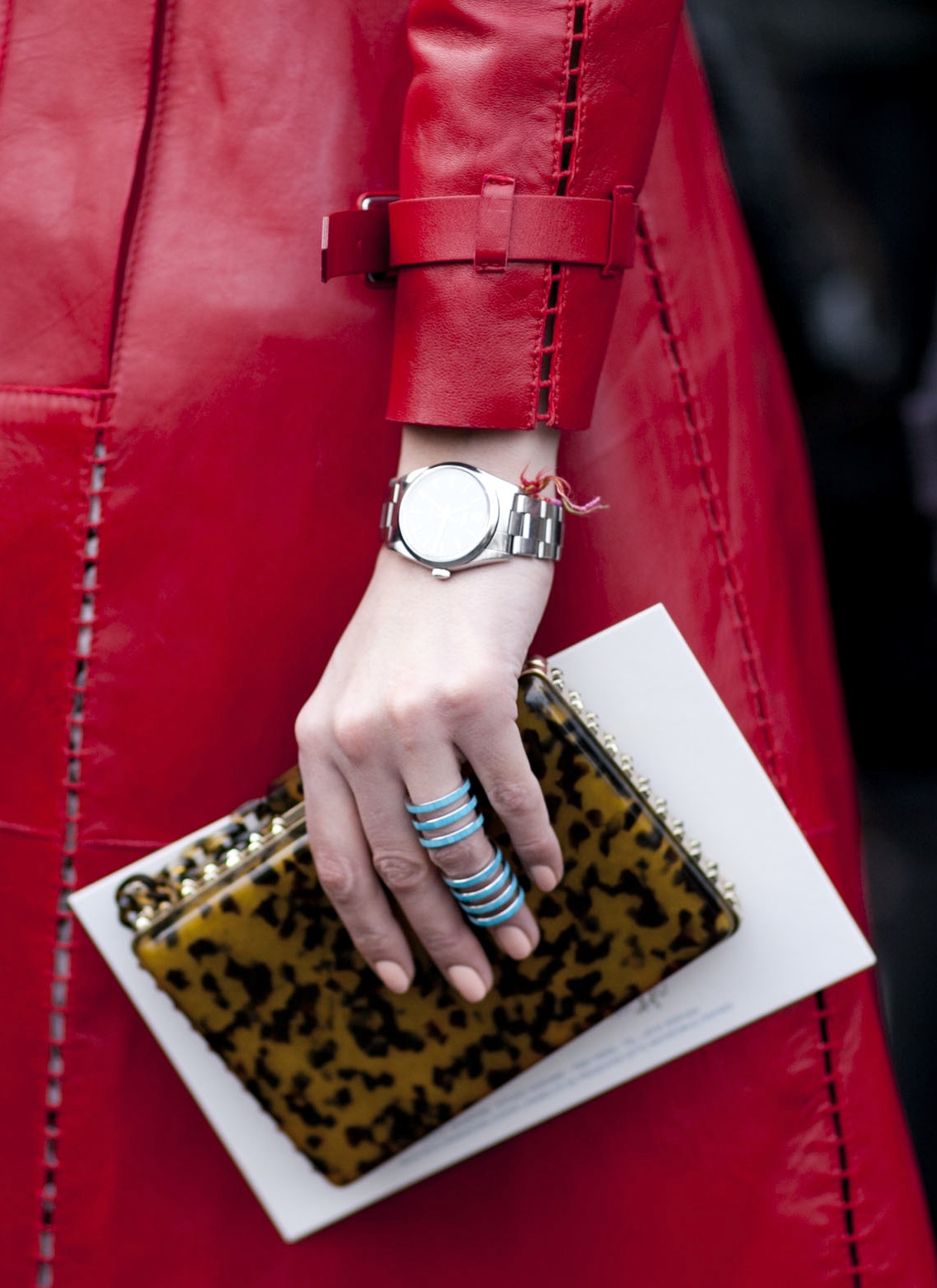 A printed clutch and turquoise Repossi ring popped against a red leather coat.
A printed clutch and turquoise Repossi ring popped against a red leather coat.