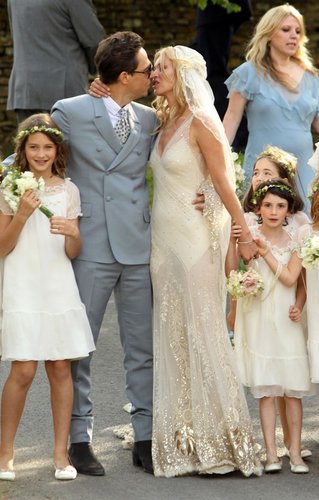 Jamie Hince and Kate Moss, wearing John Galliano, posed for a kiss following their July 1, 2011 wedding ceremony in England. We loved the elegance and effortlessness of Kate's whole bridal look, especially the daring sheer skirt.
Jamie Hince and Kate Moss, wearing John Galliano, posed for a kiss following their July 1, 2011 wedding ceremony in England. We loved the elegance and effortlessness of Kate's whole bridal look, especially the daring sheer skirt.