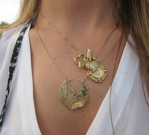 A close-up of this cluster of gold charms revealed wired and diamond hearts for love, a mini peace sign, a mythical creature as a symbol of life, and a little Chanel.
A close-up of this cluster of gold charms revealed wired and diamond hearts for love, a mini peace sign, a mythical creature as a symbol of life, and a little Chanel.