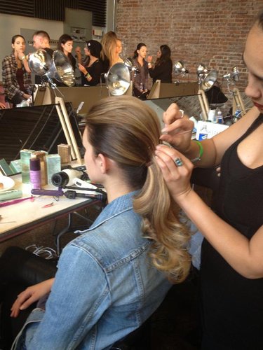 The next step: divide the hair into two sections — a smaller portion between the temples and a larger bottom part. The bottom section was secured into a low ponytail. Then the top piece was combed over the and held with bobby pins. A bride could transition back to this double ponytail look easily before the wedding reception.
The next step: divide the hair into two sections — a smaller portion between the temples and a larger bottom part. The bottom section was secured into a low ponytail. Then the top piece was combed over the and held with bobby pins. A bride could transition back to this double ponytail look easily before the wedding reception.
