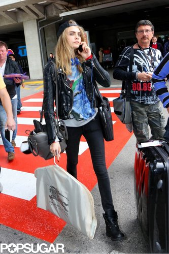 Cara Delevingne arrived in Nice wearing a black leather biker jacket with black skinny jeans, a printed tee, backwards baseball cap, and lace-up motorcycle boots.
Cara Delevingne arrived in Nice wearing a black leather biker jacket with black skinny jeans, a printed tee, backwards baseball cap, and lace-up motorcycle boots.