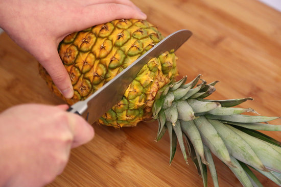 Lay the pineapple on its side and cut the top.
Lay the pineapple on its side and cut the top.