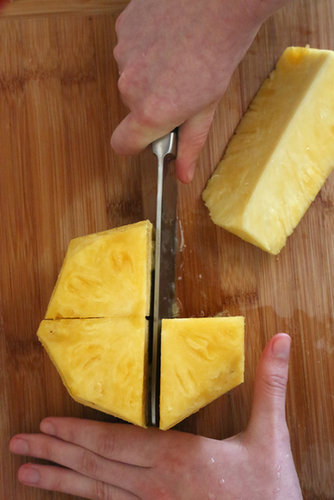 Rotate the knife 90 degrees and cut through the center again, resulting in four even pineapple pieces.
Rotate the knife 90 degrees and cut through the center again, resulting in four even pineapple pieces.