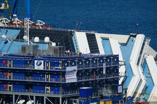 Workers stood on platforms beside the ship.
Workers stood on platforms beside the ship.