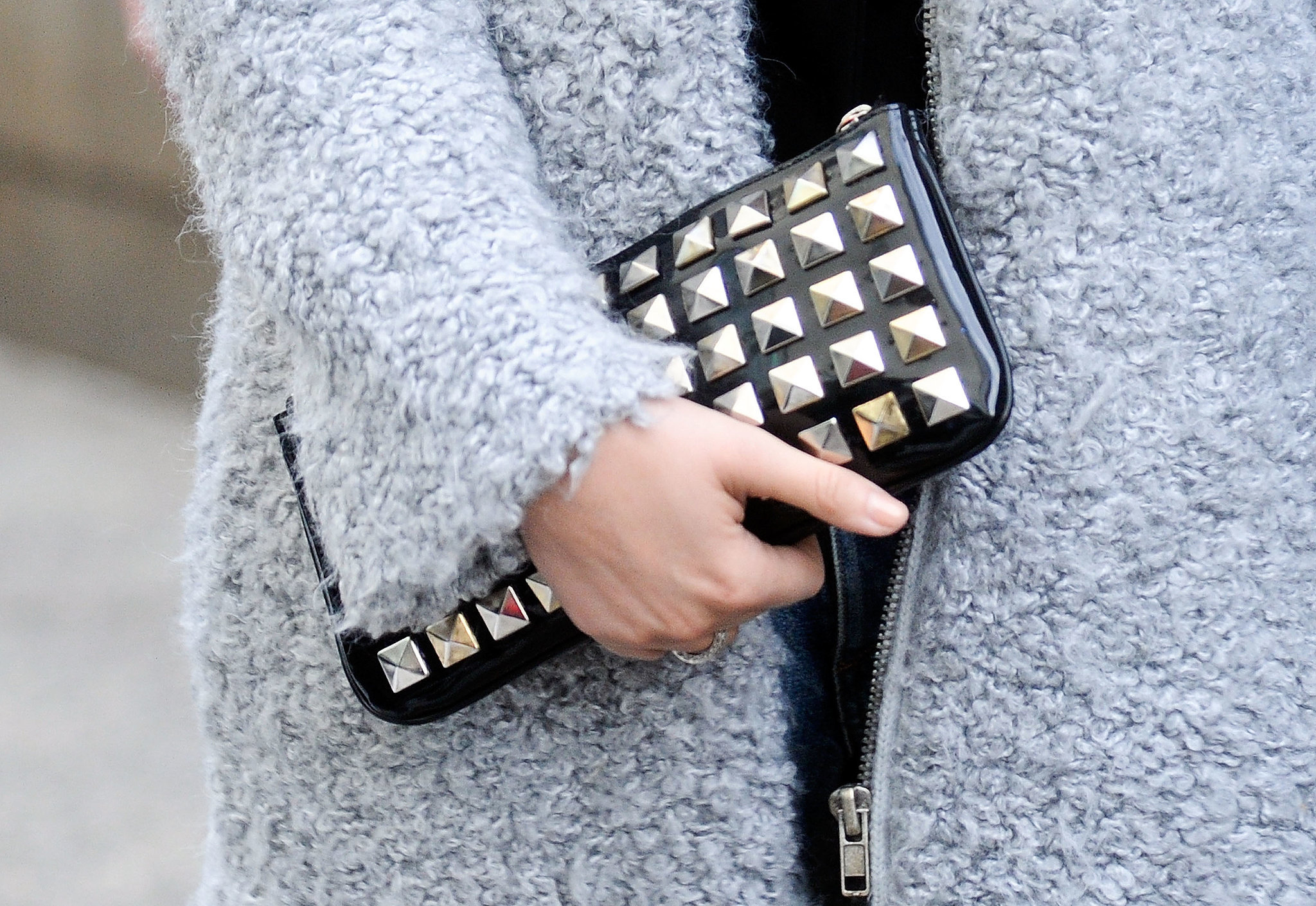 We're all about the contrast between a bouclé coat and tough-girl studded clutch. 
