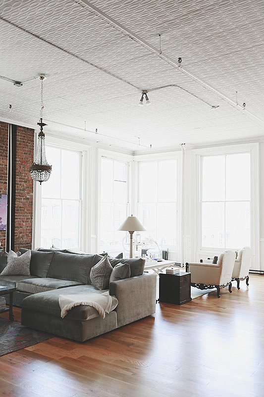 PS: What was the biggest design challenge you faced?
NS: The space itself was once an industrial textile factory — meaning wonderful 15-foot ceilings, floor-to-ceiling windows overlooking the SoHo streets, and original Corinthian columns, but few interior walls.
Since she wanted to create both a family room for sports watching and a living room for reading and relaxing without breaking up the space, we needed to create the illusion of distinctly separate spaces without constructing a wall. By anchoring both spaces with the two largest furniture pieces (the sofa and sectional from ABC Home) and decorating them with a distinct feel, we managed to draw an invisible line between the two.
Photo by Chellis Michael Photography
PS: What was the biggest design challenge you faced?
NS: The space itself was once an industrial textile factory — meaning wonderful 15-foot ceilings, floor-to-ceiling windows overlooking the SoHo streets, and original Corinthian columns, but few interior walls.
Since she wanted to create both a family room for sports watching and a living room for reading and relaxing without breaking up the space, we needed to create the illusion of distinctly separate spaces without constructing a wall. By anchoring both spaces with the two largest furniture pieces (the sofa and sectional from ABC Home) and decorating them with a distinct feel, we managed to draw an invisible line between the two.
Photo by Chellis Michael Photography