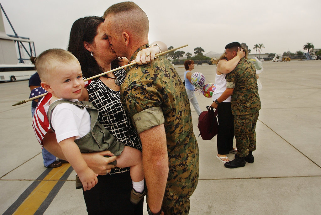 US Marine Staff Sergeant Chris Carlson kissed his wife, Kasie, as she held their 21-month-old son Ryan during the homecoming of Helicopter Squadron 466 from Iraq on July 22, 2003, at Miramar Marine Corps Air Station in San Diego, CA. His squadron's routine six-month deployment became more than a year spent overseas due to the war in Iraq, making it one of the longest deployed units in the Marine Corps.
US Marine Staff Sergeant Chris Carlson kissed his wife, Kasie, as she held their 21-month-old son Ryan during the homecoming of Helicopter Squadron 466 from Iraq on July 22, 2003, at Miramar Marine Corps Air Station in San Diego, CA. His squadron's routine six-month deployment became more than a year spent overseas due to the war in Iraq, making it one of the longest deployed units in the Marine Corps.