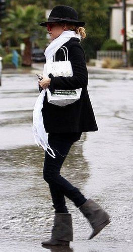 Nicole Richie Walks in the Rain in Gray Wedge Boots, White Scarf, and Black Fedora Hat