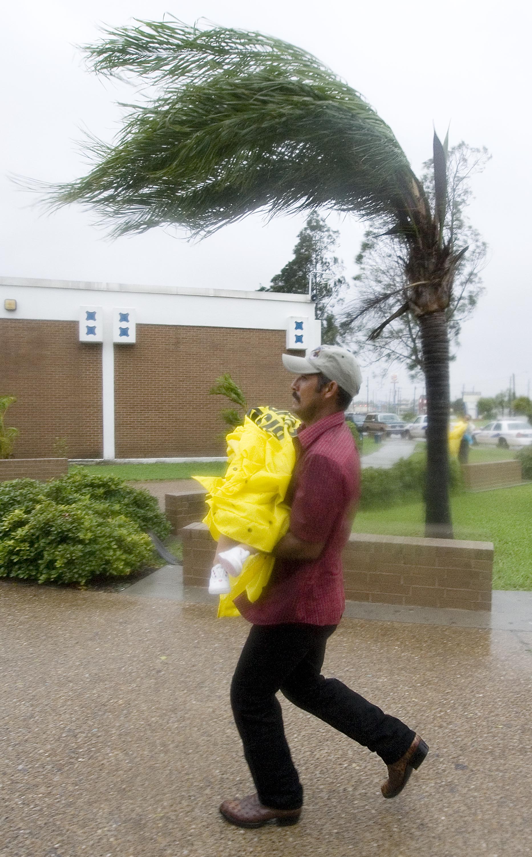 Evacuee runs with his bundled up daughter to a shelter. Evacuee runs with his bundled up daughter to a shelter.