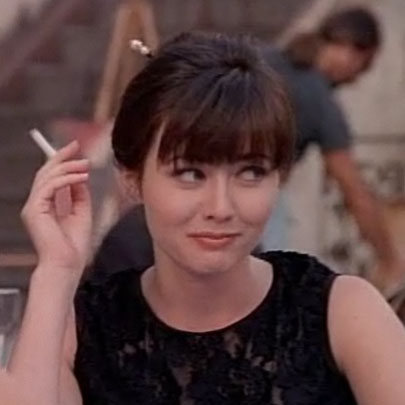 Brenda smokes her first cigarette in France, where she also uses sticks to keep her bun in place.
Brenda smokes her first cigarette in France, where she also uses sticks to keep her bun in place.