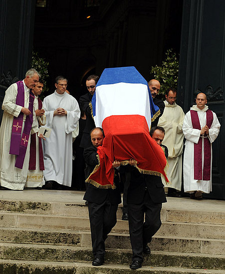 Pallbearers carry Saint Laurent's coffin.