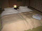 After dinner, they move the table out of the way and lay out the beds.